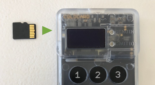 Inserting a MicroSD card into the top slot of a Coldcard hardware wallet for air-gapped data transfer